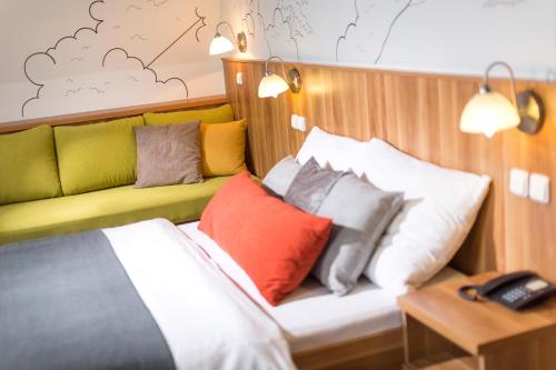 a bedroom with a bed with colorful pillows at Wellness Hotel Grand in Špindlerův Mlýn