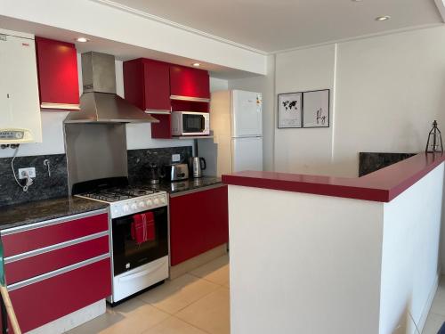 a kitchen with red and white cabinets and appliances at Administración MAIPU 3B DEPTO PREMIUM in Tandil