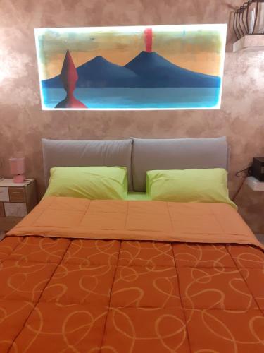 una camera da letto con un letto e un dipinto sul muro di Al numero 1 a Napoli