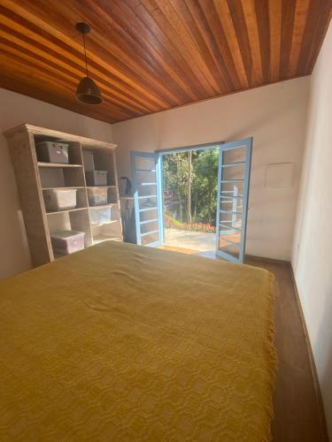 um quarto com uma cama e um tecto em madeira em Casa de campo com muito verde e paz/2 quartos/Wi-Fi/churrasqueira/ deck/ trilha/ minha cachoeira em Rio Acima