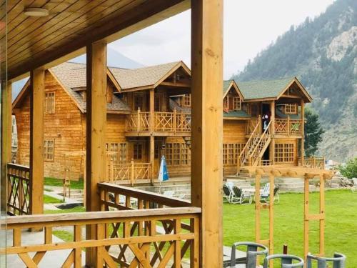 a log cabin with a porch and a deck at Swiss Wood Cottages Naran in Nārān