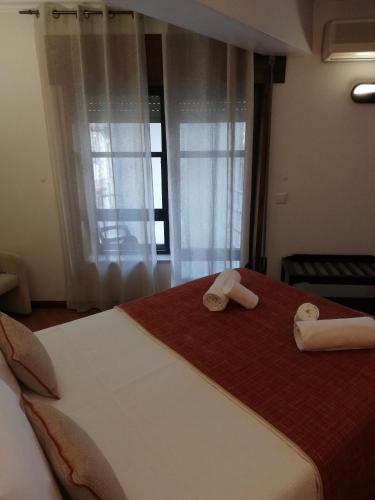 a bedroom with a bed with two towels on it at Hotel Termas in Chaves
