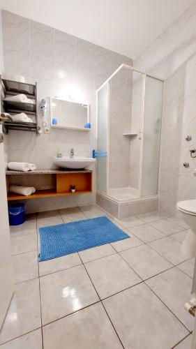 a white bathroom with a sink and a shower at IstraNova Apartments in Rovinj