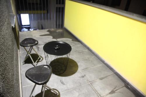 a room with three stools and a yellow wall at Luxury Downtown Apartment in Cluj-Napoca