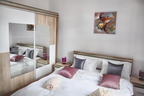 a bedroom with a large white bed with pink pillows at Luxury Downtown Apartment in Cluj-Napoca