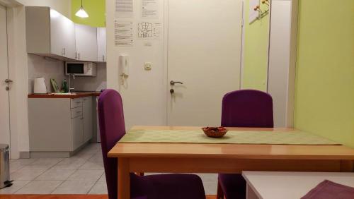 a kitchen with a wooden table and purple chairs at IstraNova Apartments in Rovinj