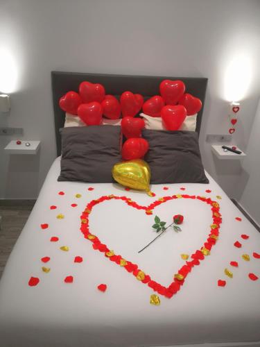 a bed with a heart made out of red roses at ERES EMÉRITA "Apartamentos & Suites" in Merida