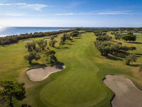an aerial view of a golf course with the ocean at Fiordo Topazio in Isola Albarella