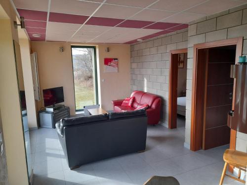 a living room with a couch and a tv at Gîte Le Chant des Cloches in Fleurey