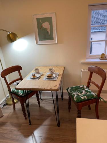 a dining room table with two chairs and a table with two cups at Loft in Bungay in Bungay