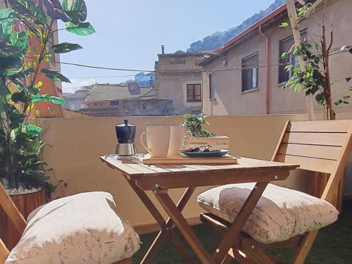 a wooden table and two chairs on a balcony at SUITE BLANC APARTMENTS - Monolocali indipendenti con cucina e bagno privato - Check-in e check-out con codice in autonomia h24 - Terrazza in comune NECESSARIO AVERE WATHSAPP O APP DI MESSAGGISTICA ISTANTANEA PER FOTO E VIDEO in Guspini