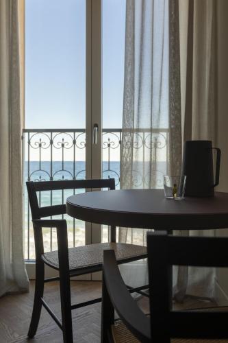 a room with a table and chairs and a large window at Hotel Windsor in Laigueglia