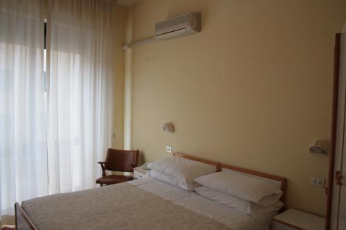 una camera d'albergo con letto e sedia di Hotel Risorgimento a Chianciano Terme