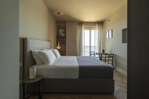 a bedroom with a large bed and a dining room at Hotel Windsor in Laigueglia
