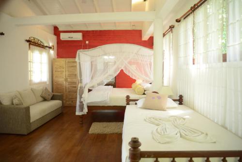 a bedroom with a bed and a couch in a room at Thambapanni Retreat in Unawatuna