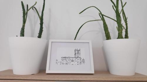 three white vases sitting on a shelf with a picture at APARTAMENTO LA REAL in Nájera