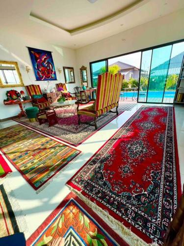 a living room with lots of rugs on the floor at Colorful Pool Villa, Chiang Rai, Thailand in Chiang Rai