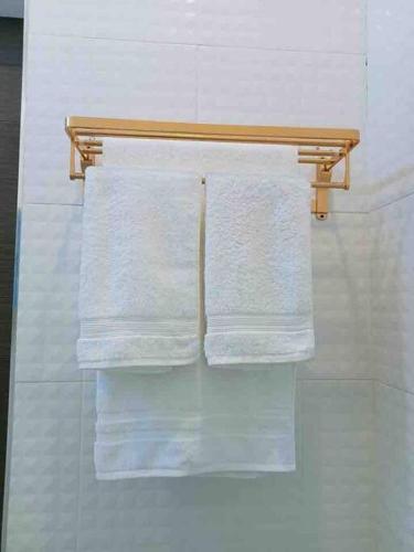 a group of towels hanging on a rack in a bathroom at Colorful Pool Villa, Chiang Rai, Thailand in Chiang Rai