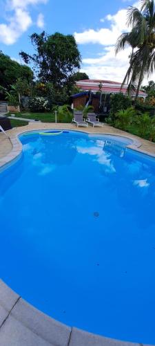 a large blue swimming pool with two chairs in it at LE MANGUIER in Baie-Mahault
