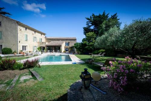 une cour avec une maison et une piscine dans l'établissement Le mas d'Orsan chambres d'hôtes, à Orsan