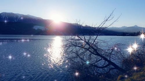 a body of water with the sun shining on it at Ferienhaus Sonnenstrahl in Gmünd in Kärnten