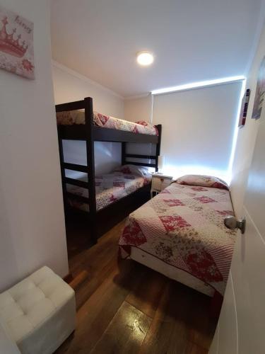 a room with two bunk beds in a room at Papudo Laguna Apartment in Papudo