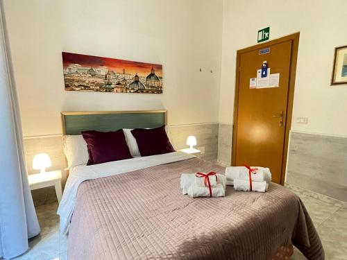 een slaapkamer met een bed met twee handdoeken erop bij Roman Holidays Rooms Otranto in Rome
