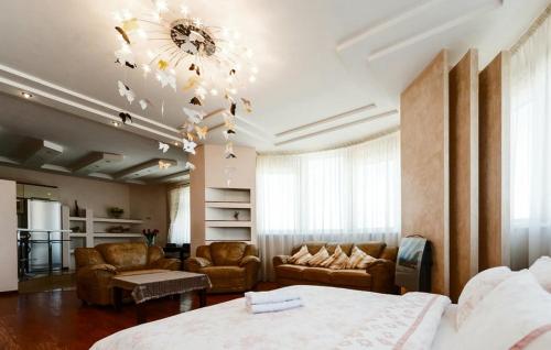 een slaapkamer met een bed, een bank en een kroonluchter bij Роскошная 3к квартира 135м2 на набережной. Минская in Kiev