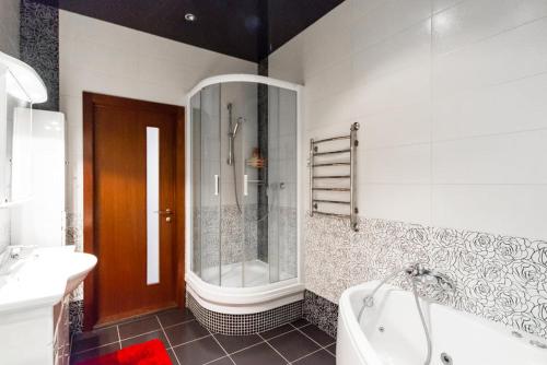 een badkamer met een bad, een douche en een wastafel bij Роскошная 3к квартира 135м2 на набережной. Минская in Kiev