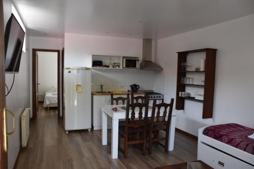 a kitchen with a white refrigerator and a table and chairs at La MagnoliaII zona Güemes in Mar del Plata