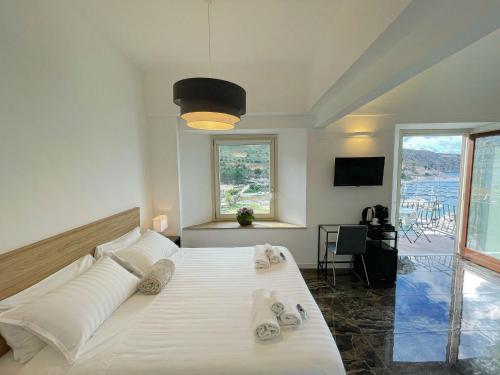 a bedroom with a large white bed with towels on it at Suite Altamarea "Sea View Studios" in Castellammare del Golfo