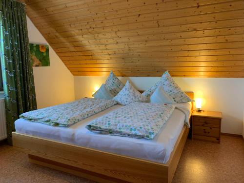 Schlafzimmer mit einem Bett mit Holzdecke in der Unterkunft Gästehaus Hundelbach in Lenzkirch