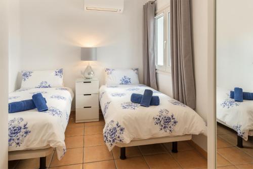 een slaapkamer met 2 aparte bedden en een spiegel bij Lanzahost Villa Ona in Costa Teguise