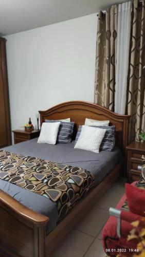 a bedroom with a wooden bed with pillows on it at Willa Sandal in Eilat