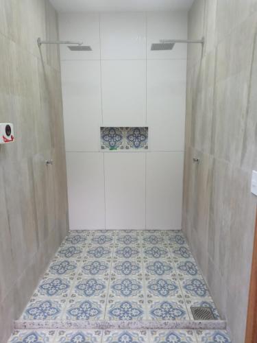 a bathroom with a shower with a tiled floor at Eco Chalés Águas Claras in Lumiar
