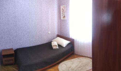 Un dormitorio con una cama con un teléfono. en Comfortable apartments in centre with 3 bedrooms, en Rivne