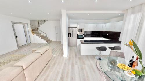 a white living room with a couch and a kitchen at Villa Cassolino in Ribeira Brava