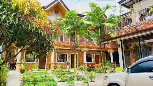 a house with palm trees in front of it at Villa Marii in Dipolog