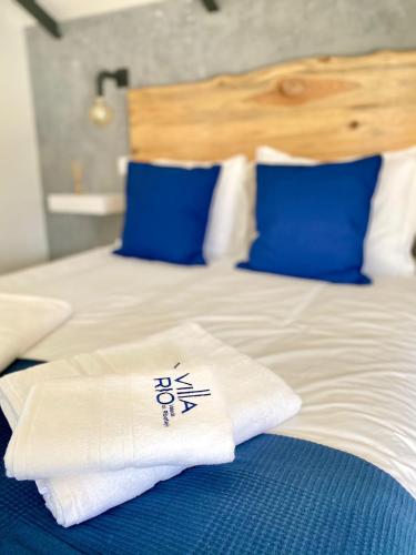 a bed with blue and white sheets and blue pillows at Villa Rio by Valada Village in Valada