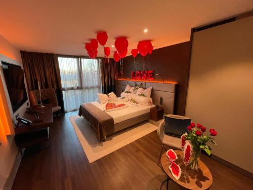 a bedroom with a bed and a living room with red balloons at Innspire Hotel in Munich