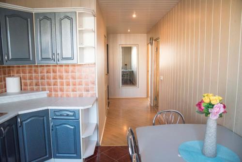 a kitchen with a vase of flowers on a table at Lovely 2-bedroom Flat in Šiauliai in Šiauliai