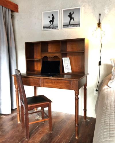 a desk with a laptop on it in a bedroom at Guest House & Art Gallery in Olinda