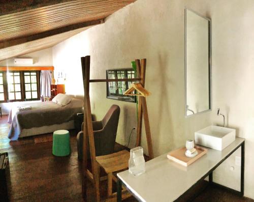 a bedroom with a bed and a desk in a room at Guest House & Art Gallery in Olinda