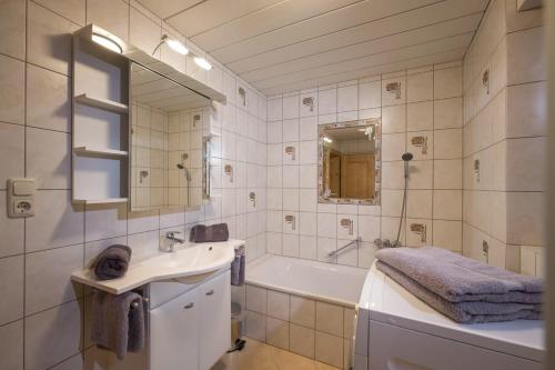 ヴェステンドルフにあるHaus Auni Metzgermeisterのバスルーム(シンク、バスタブ、鏡付)