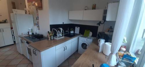 a kitchen with white cabinets and a washing machine at Naturalne Cuda i Przebudzenie Mocy in Gdynia