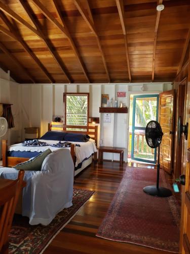 a bedroom with a bed and a fan in it at Carolyn's Other House- Gold Standard Certified in Caye Caulker