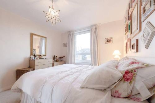 a white bedroom with a large white bed with pillows at Spacious Two Double Bedroom Flat in London