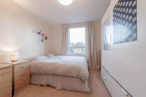 a white bedroom with a bed and a window at Spacious Two Double Bedroom Flat in London