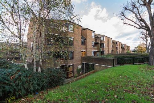 a large brick building with a green yard in front of it at Spacious Two Double Bedroom Flat in London