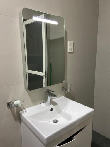 a bathroom with a white sink and a mirror at Sea view A in Mount Lavinia